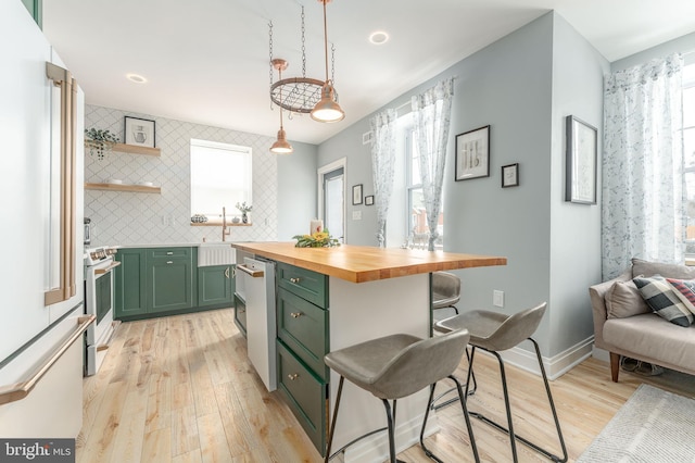 kitchen featuring white range with electric cooktop, wooden counters, green cabinets, decorative backsplash, and decorative light fixtures