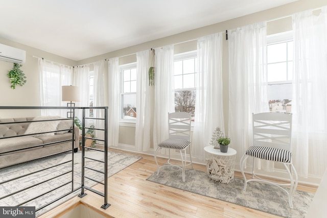 interior space with hardwood / wood-style floors and a wall unit AC