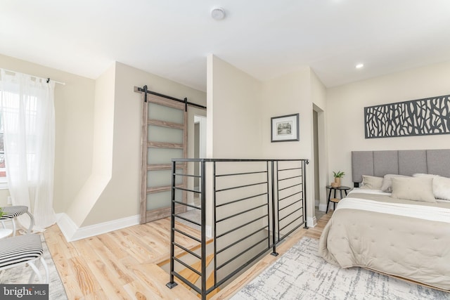 bedroom featuring light hardwood / wood-style flooring and a barn door