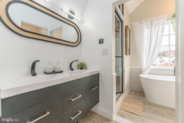 bathroom featuring vanity and independent shower and bath