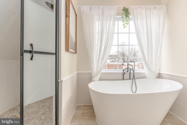 bathroom featuring shower with separate bathtub