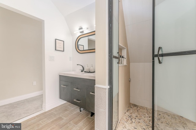 bathroom featuring vanity, vaulted ceiling, and an enclosed shower