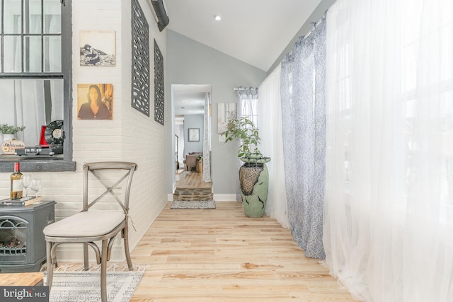 hallway featuring light hardwood / wood-style flooring and lofted ceiling