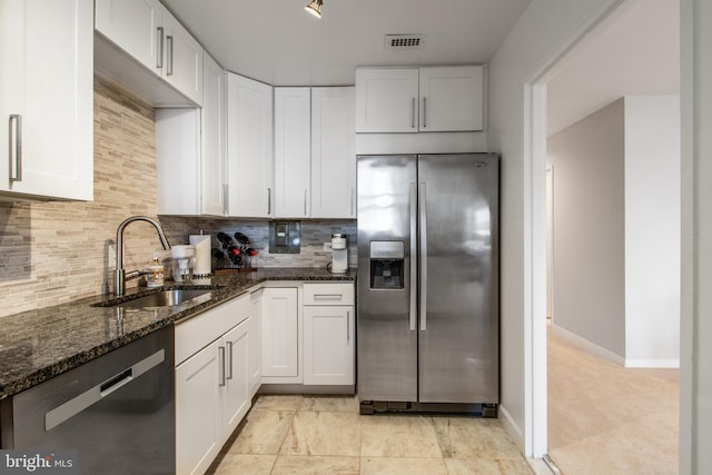 kitchen with white cabinets, dishwasher, dark stone countertops, sink, and stainless steel fridge with ice dispenser