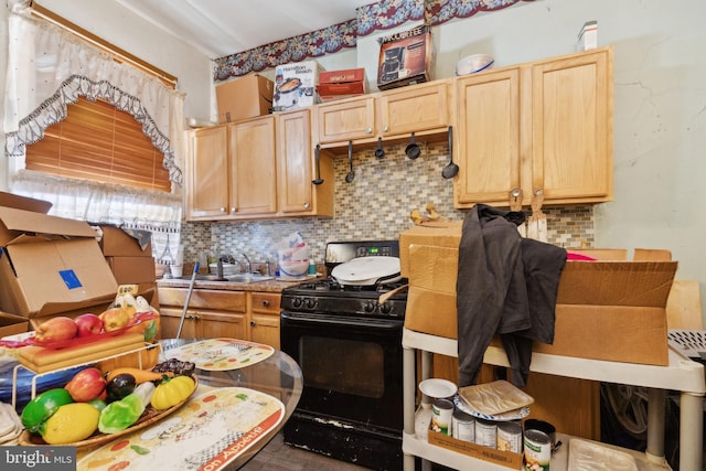 kitchen with black range with gas stovetop, light brown cabinets, sink, and decorative backsplash