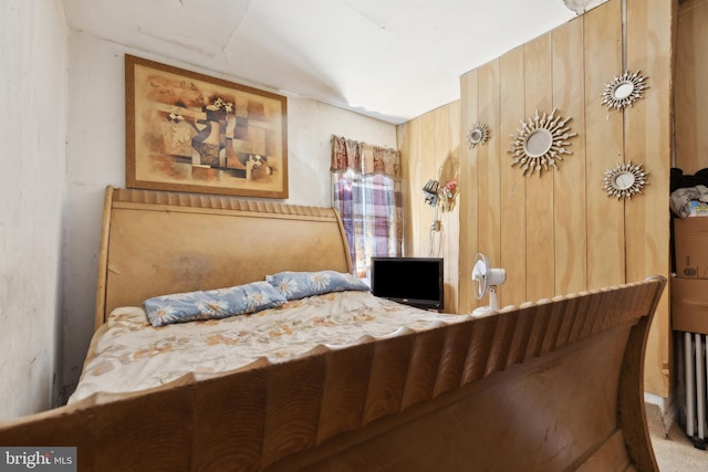 bedroom featuring wooden walls