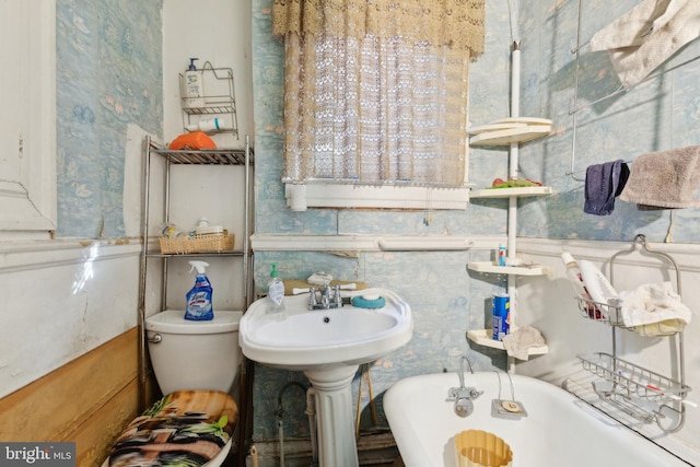 bathroom with toilet and a tub