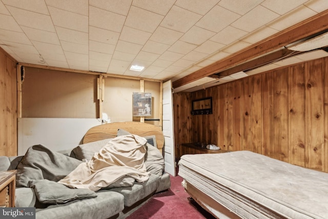 bedroom featuring wooden walls and carpet