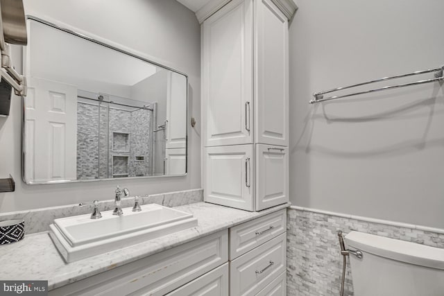 bathroom with vanity, toilet, walk in shower, and tile walls