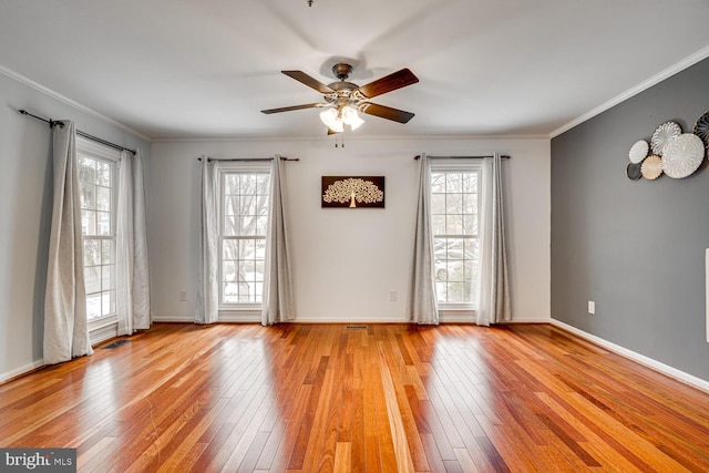 unfurnished room with light hardwood / wood-style floors, a wealth of natural light, ornamental molding, and ceiling fan