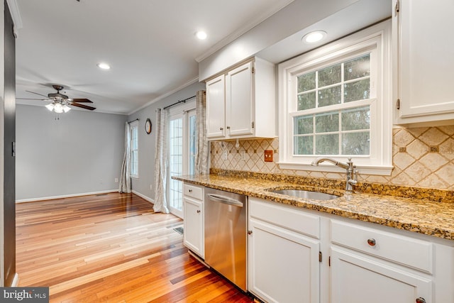 kitchen with sink, stainless steel dishwasher, white cabinets, and light stone countertops