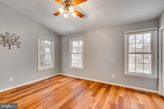 spare room with ceiling fan, light hardwood / wood-style flooring, a healthy amount of sunlight, and vaulted ceiling