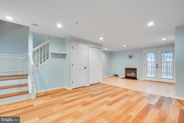 unfurnished living room with french doors and light wood-type flooring