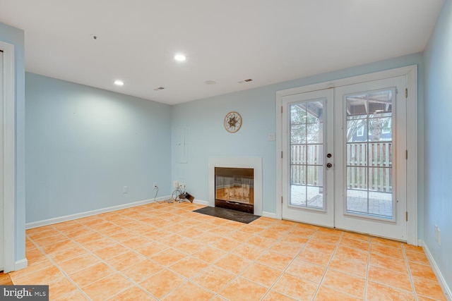 unfurnished living room with light tile patterned flooring and french doors