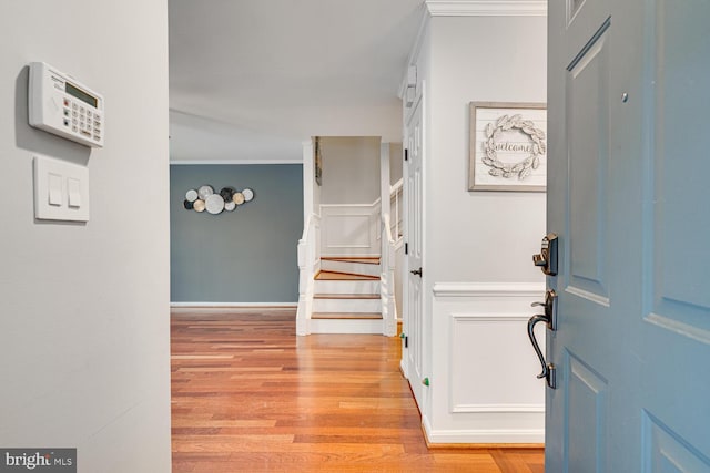 foyer featuring crown molding and light hardwood / wood-style flooring