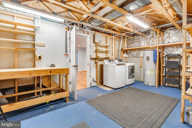 basement with washer and clothes dryer, electric water heater, and a workshop area