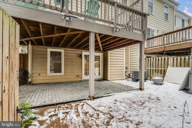 snow covered patio featuring a wooden deck and central AC unit