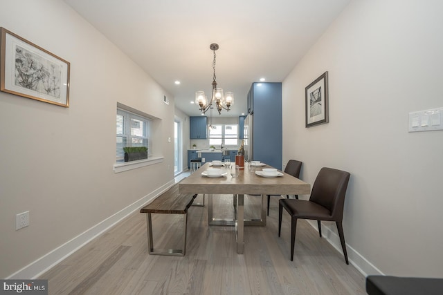 dining area featuring light wood-type flooring and an inviting chandelier