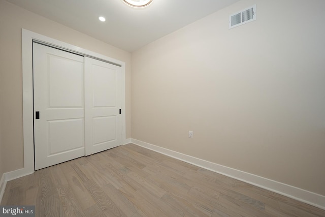 unfurnished bedroom featuring light hardwood / wood-style floors and a closet