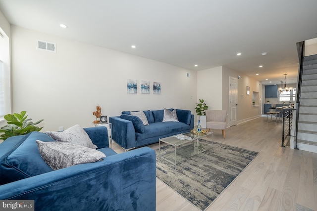 living room featuring a chandelier and light hardwood / wood-style flooring