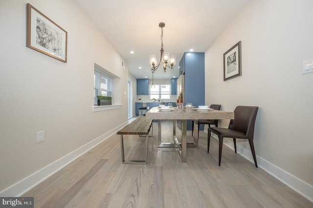 dining space with an inviting chandelier and light hardwood / wood-style floors