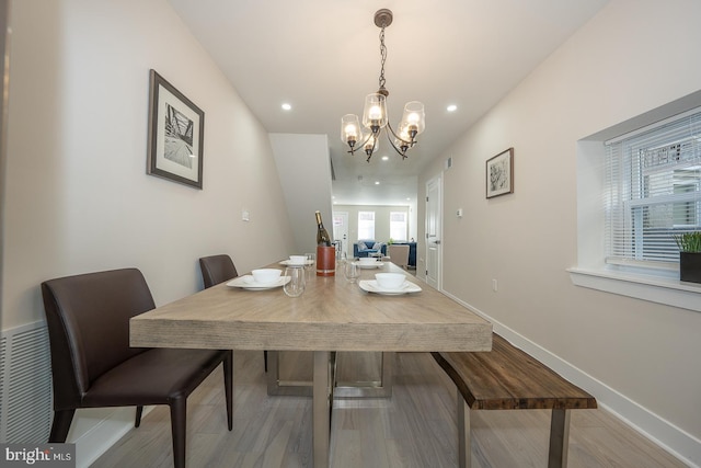 dining room with light wood-type flooring and a chandelier