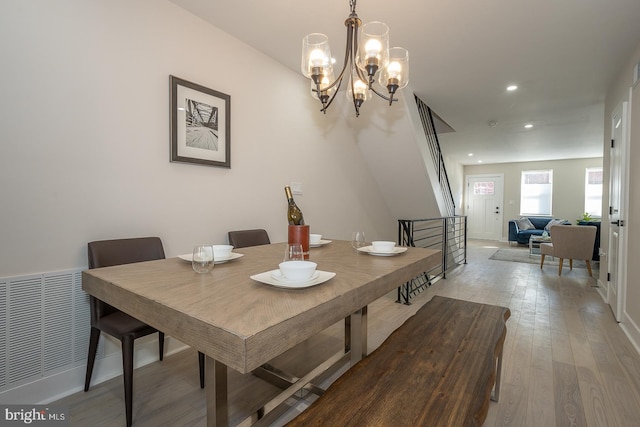 dining space with a notable chandelier and hardwood / wood-style flooring