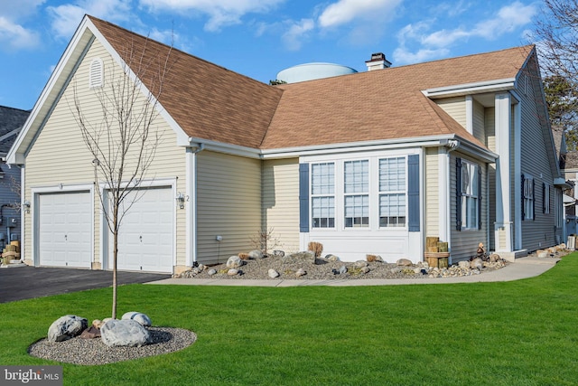 view of front of house with a front yard and a garage