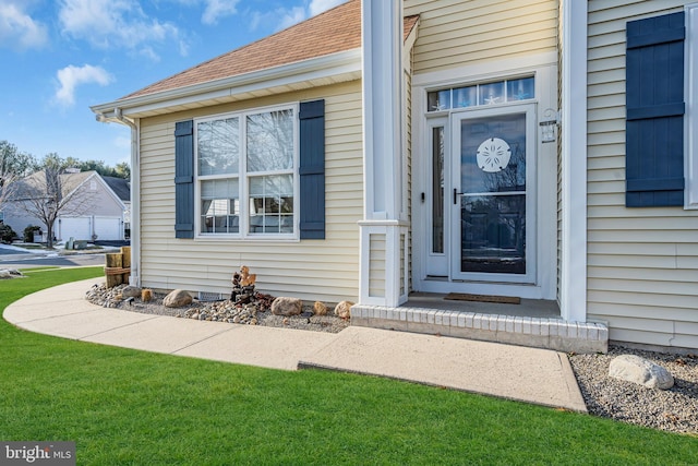 doorway to property featuring a lawn