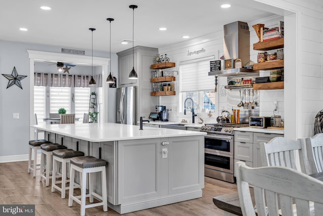 kitchen with pendant lighting, gray cabinets, stainless steel appliances, and extractor fan