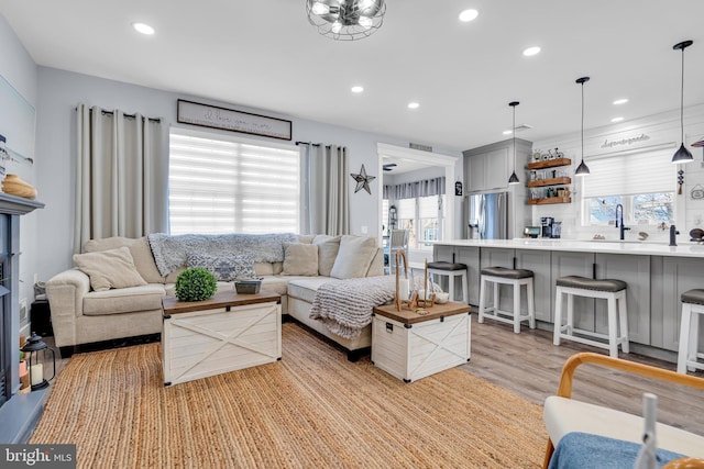 living room featuring sink and light hardwood / wood-style flooring