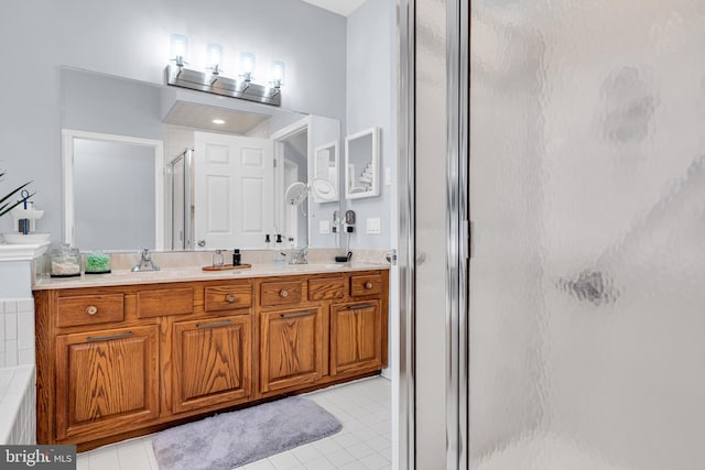 bathroom with tile patterned floors, a shower with door, and vanity