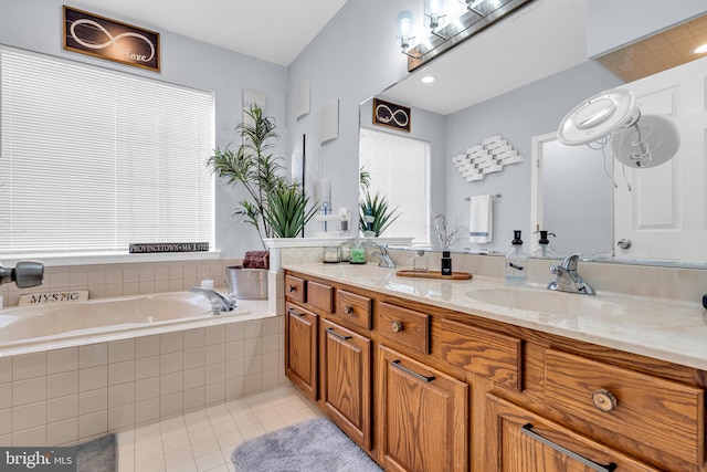 bathroom with tile patterned floors, tiled tub, and vanity