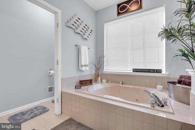 bathroom with tiled bath and tile patterned flooring