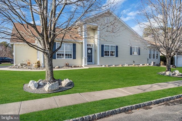 view of front of property with a front lawn and central AC unit