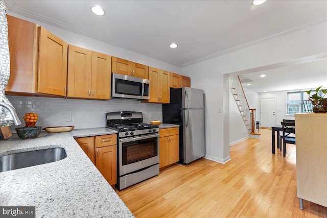 kitchen featuring decorative backsplash, sink, crown molding, and stainless steel appliances