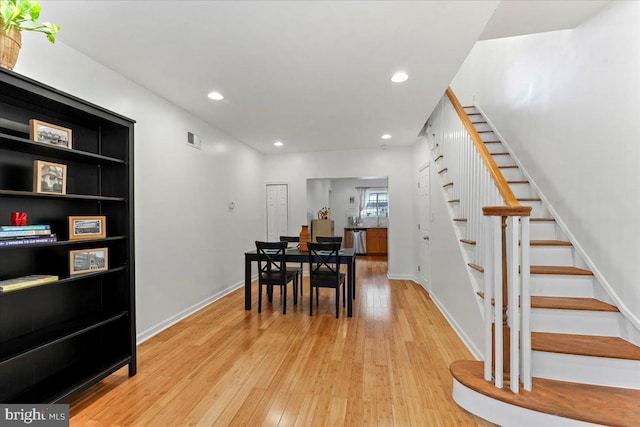 dining area with light hardwood / wood-style floors and built in shelves