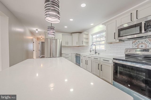 kitchen featuring appliances with stainless steel finishes, backsplash, decorative light fixtures, white cabinets, and sink