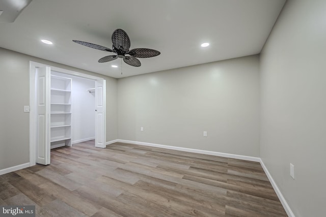 unfurnished bedroom featuring light wood-type flooring, ceiling fan, a closet, and a spacious closet