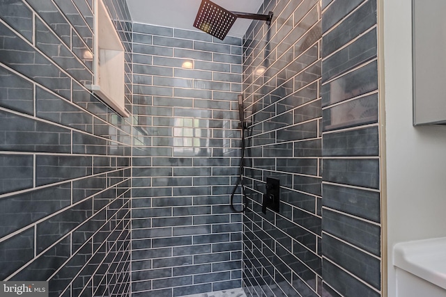 bathroom with toilet and a tile shower