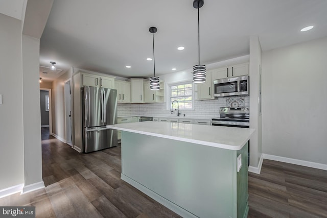 kitchen featuring dark hardwood / wood-style floors, a kitchen island, sink, hanging light fixtures, and appliances with stainless steel finishes