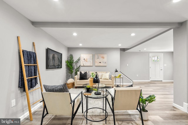 living room with beam ceiling and light wood-type flooring