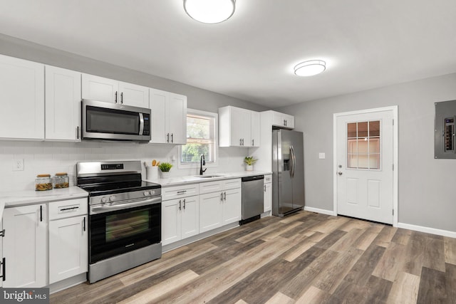 kitchen with white cabinetry, appliances with stainless steel finishes, backsplash, dark wood-type flooring, and sink