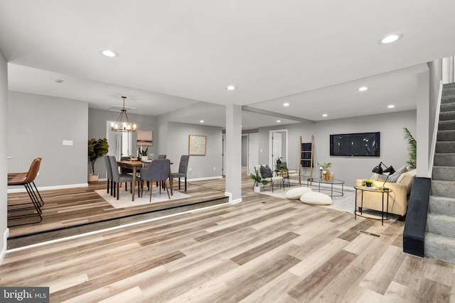 living room with light wood-type flooring and an inviting chandelier