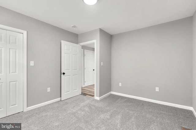 unfurnished bedroom with a closet and carpet flooring