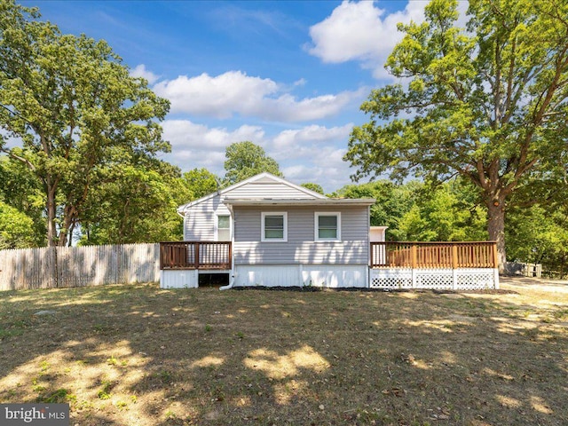 rear view of house featuring a deck and a yard