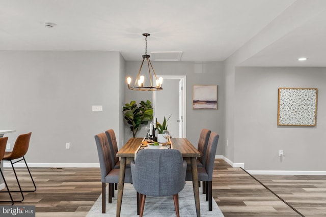 dining room with wood-type flooring and a notable chandelier