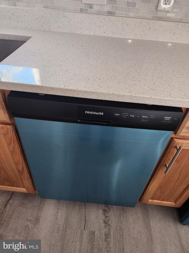 room details featuring stainless steel dishwasher, light stone countertops, and sink