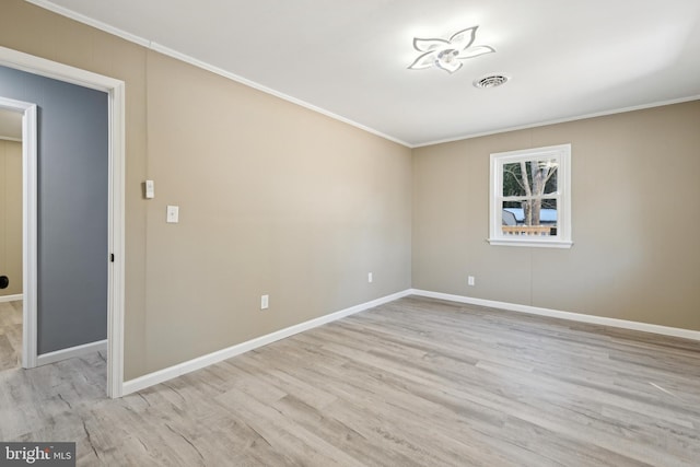 spare room with light wood-type flooring and ornamental molding