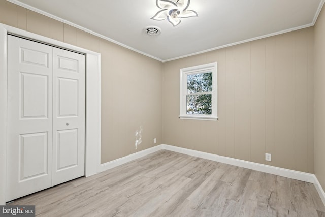 unfurnished bedroom featuring light hardwood / wood-style floors, a closet, and ornamental molding